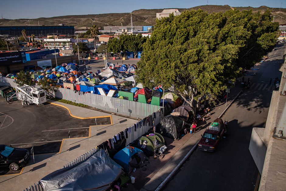Migrants gather at the El Chaparral migrant camp