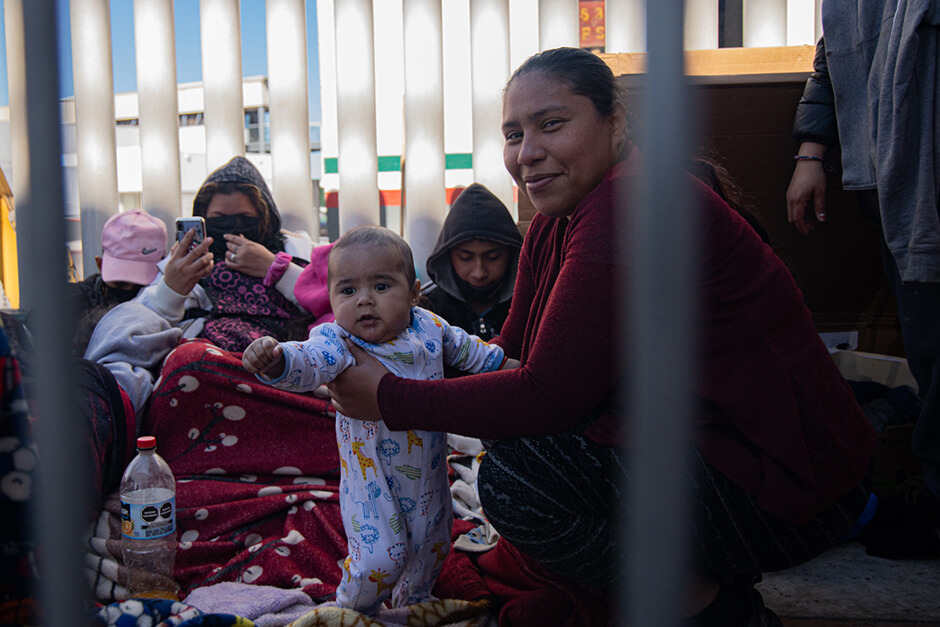 Mother and baby have been sleeping on the sidewalk for weeks at the El Chaparral migrant camp in Tijuana